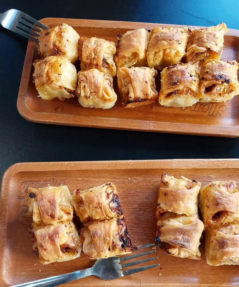 Two trays of baked mantia on a café table