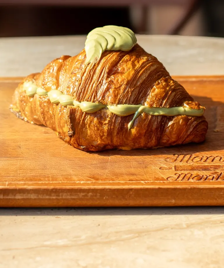 Pistachio croissant on a wooden board