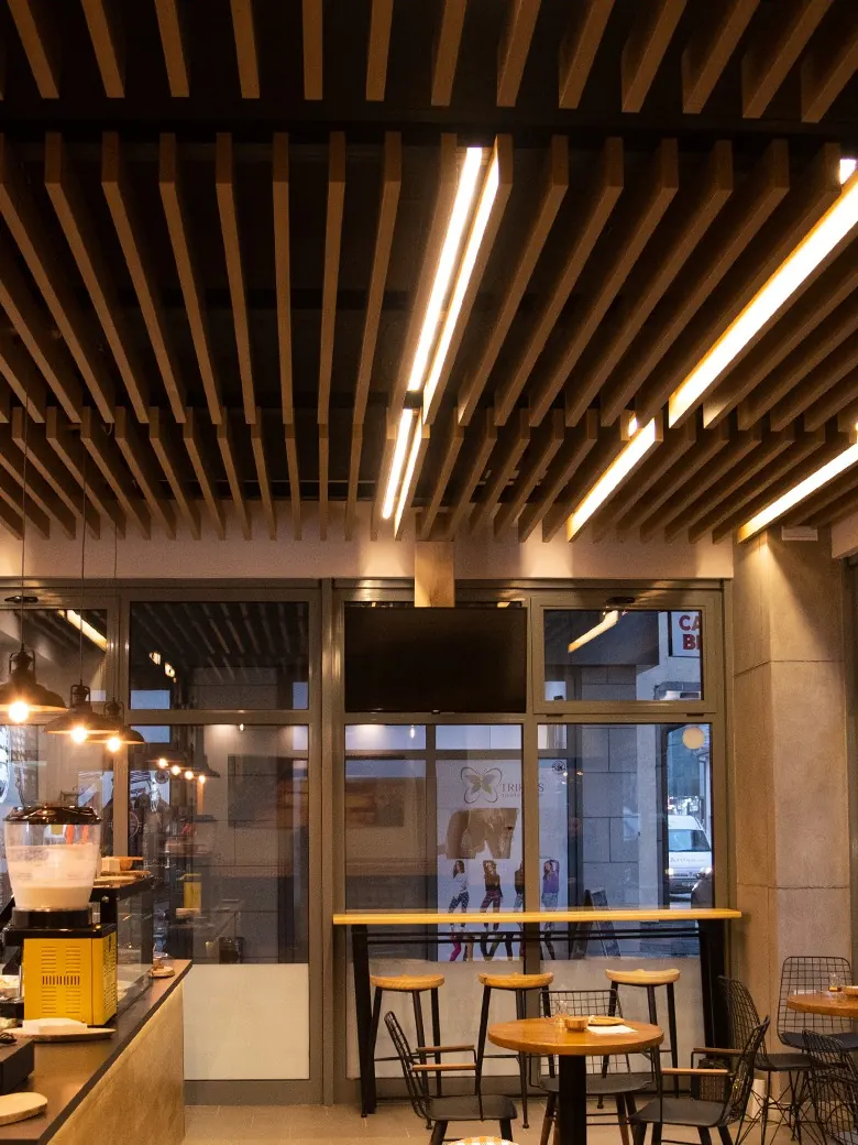 The café inside, with a wooden-slat ceiling and small tables